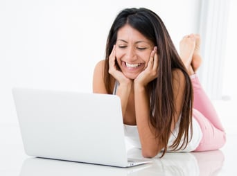 Happy woman chatting online on her laptop computer