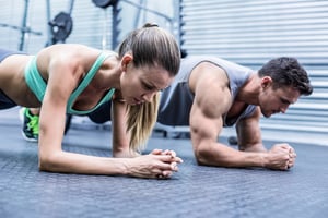 Side view of a muscular couple doing planking exercises-1