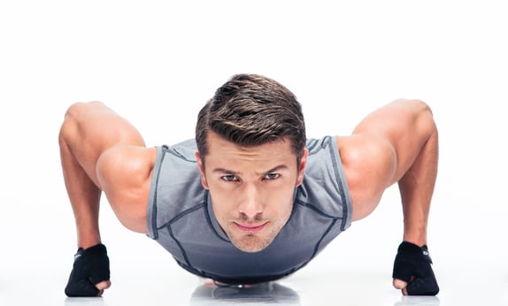 Sports young man doing push ups isolated on a white background
