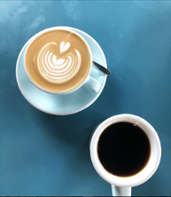 two_coffee_cups_on_blue_table