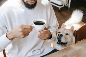 Man having coffee with dog