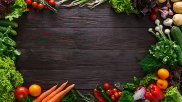 Vegetables laid on a dark brown wood table.